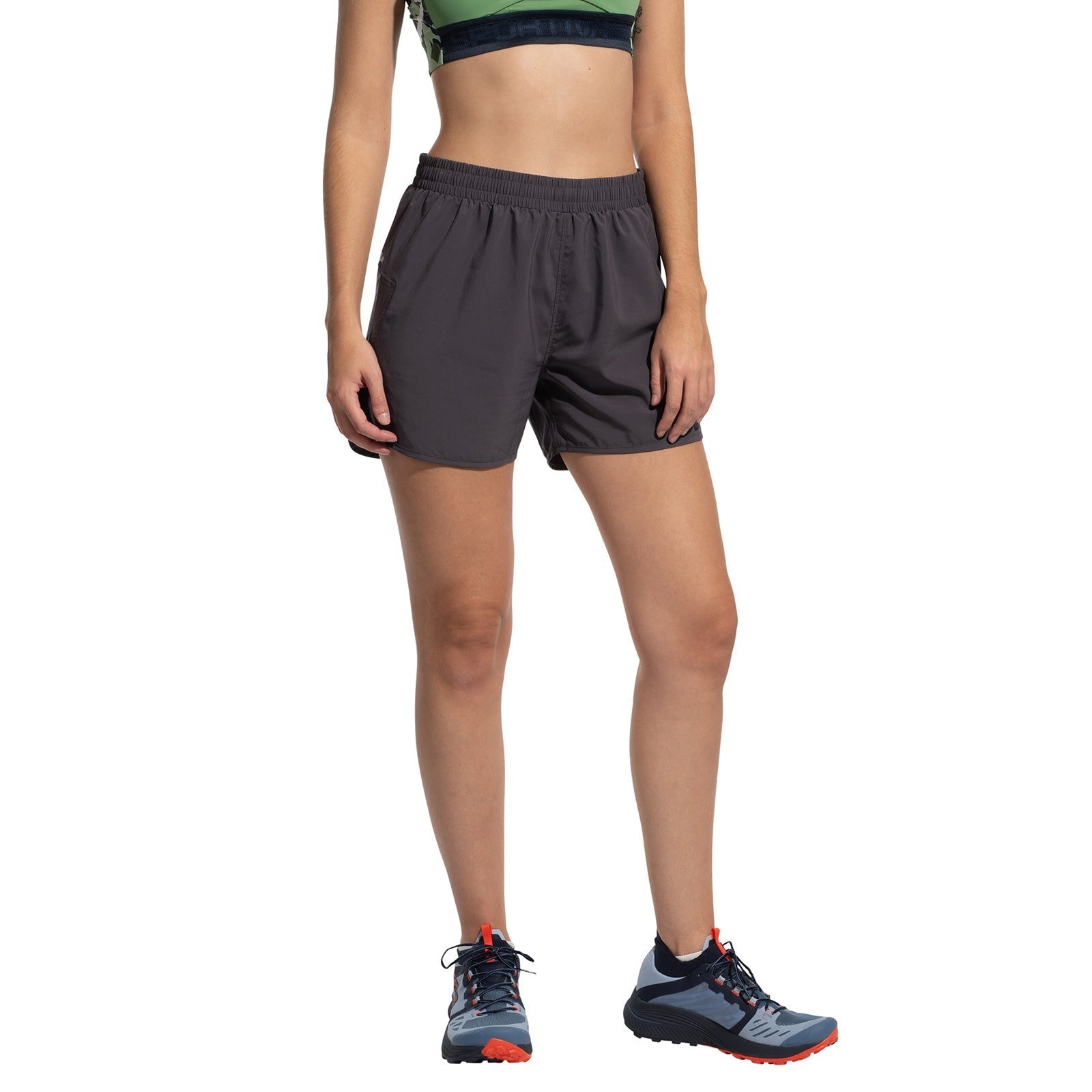 A person wearing La Sportiva Sudden Shorts Women's stands against a white background. The cropped athletic top and trail running shoes are visible, but the person's head is not shown in the image.