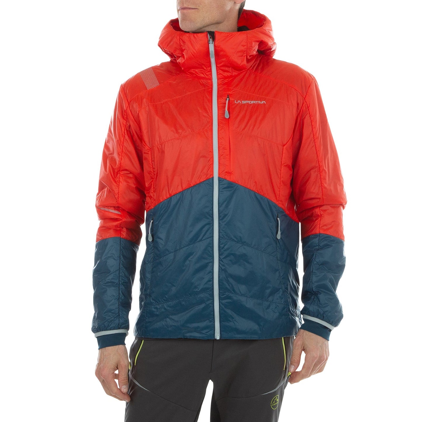 A person stands against a white background wearing the La Sportiva Alpine Guide Primaloft Hoody Men's (2024), a red and navy blue lightweight jacket with a shiny finish and front zipper, their head slightly turned to the side.