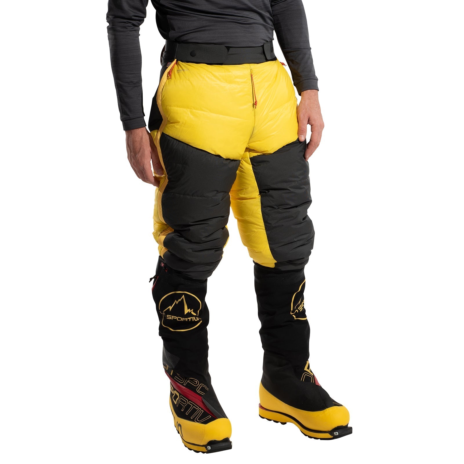 A person wearing La Sportiva Olympus Tech Down Pants Men's in yellow and black, inspired by Himalayan expeditions, stands against a white background. Only the lower half of the body is visible.