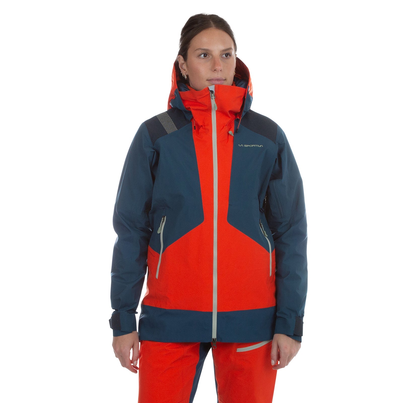 A person in a La Sportiva Supercouloir GTX Pro Jacket Women's (2024) with hood and matching pants stands against a white background. High collar and zippered pockets offer ideal winter protection. Red and navy Gore-Tex PRO construction.
