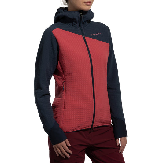 A woman wearing the La Sportiva Bristen Thermal Hoody Women's, a red and navy blue fleece with a textured pattern ideal for outdoor activities, stands against a plain white background.