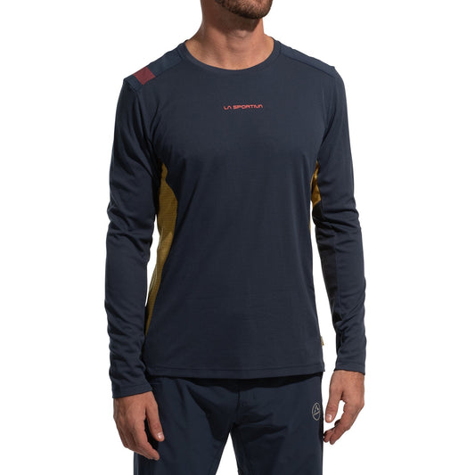 A man is wearing the La Sportiva Beyond Long Sleeve Men's (2025) in navy with yellow side panels, Polartec Delta Cooling Fabric, and a small red chest logo, standing against a plain white background.