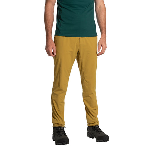 A person models La Sportiva Trail Guard Pants Men's (2025) in mustard yellow, shown from the waist down against a plain white background, paired with a dark green shirt and black hiking boots.