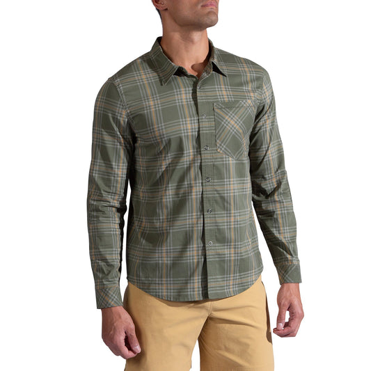 A man wearing the La Sportiva Outer Space Long Sleeve Shirt Men's in green and gray plaid with reinforced elbows and a front pocket, paired with light tan pants, stands against a white background.