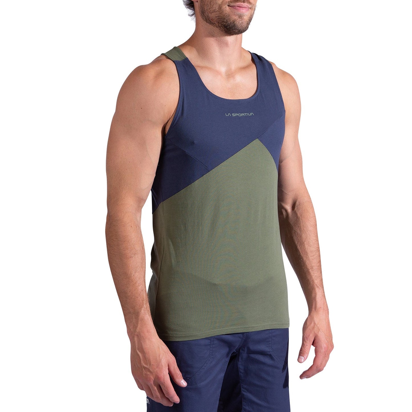 A man is wearing the La Sportiva Dude Tank Men's, featuring navy blue and olive green color blocks with La Sportiva branding on the chest, and blue shorts. He is standing against a white background.