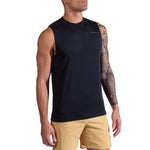 A man with a tattoo sleeve on his left arm stands facing slightly to the side in a La Sportiva Just Right Tank Men's in black and beige shorts against a white background.