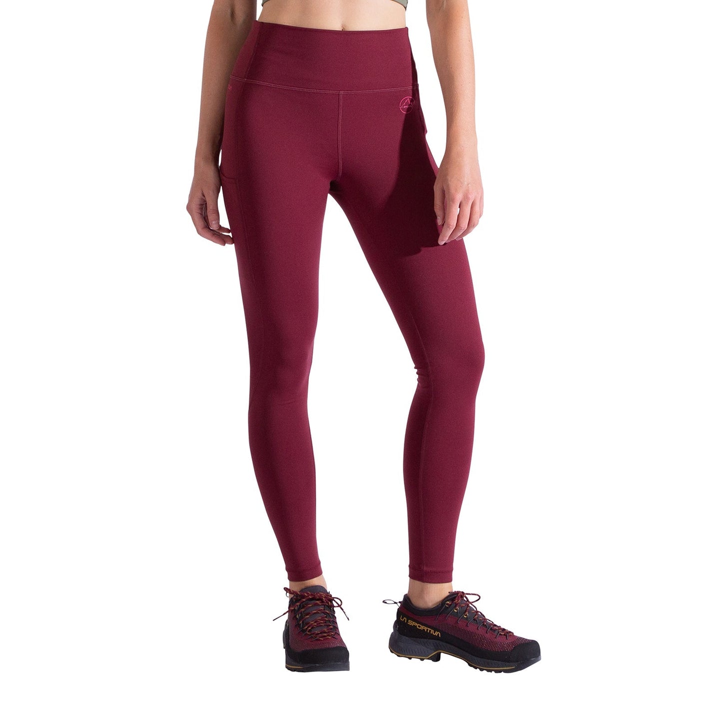 A person wears high-waisted, maroon La Sportiva Cosmosis Leggings Women's and black hiking shoes, standing against a white background; only the body from the shoulders down is visible.