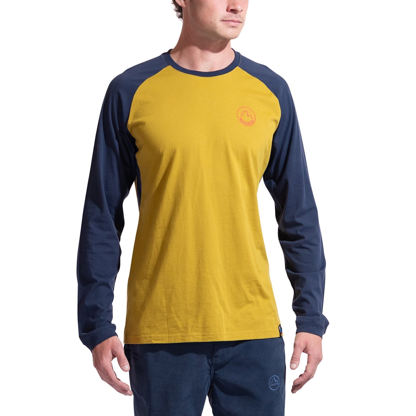 A minimalist climber wears the La Sportiva Circle Logo Long Sleeve Men's shirt in yellow with navy sleeves and matching pants, standing against a white background. A small logo accents the left chest of the shirt.