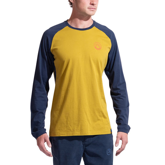 A minimalist climber wears the La Sportiva Circle Logo Long Sleeve Men's shirt in yellow with navy sleeves and matching pants, standing against a white background. A small logo accents the left chest of the shirt.