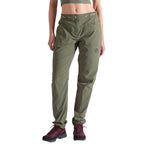 A person wears La Sportiva Mantra Pants Women's in olive green, featuring articulated knees, a logo on the left thigh, and a relaxed fit, along with black-and-red hiking shoes. They stand against a white background with the upper body partially visible.