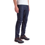 A person wearing Rincon Jeans Men's by La Sportiva, a white T-shirt, and black hiking shoes with orange laces stands against a plain white background.