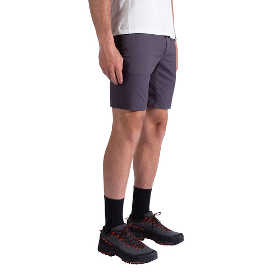 A person wearing La Sportiva Mainliner Shorts Men's, a white T-shirt, black socks, and black hiking shoes with red laces stands against a plain white background; only their lower body is visible.