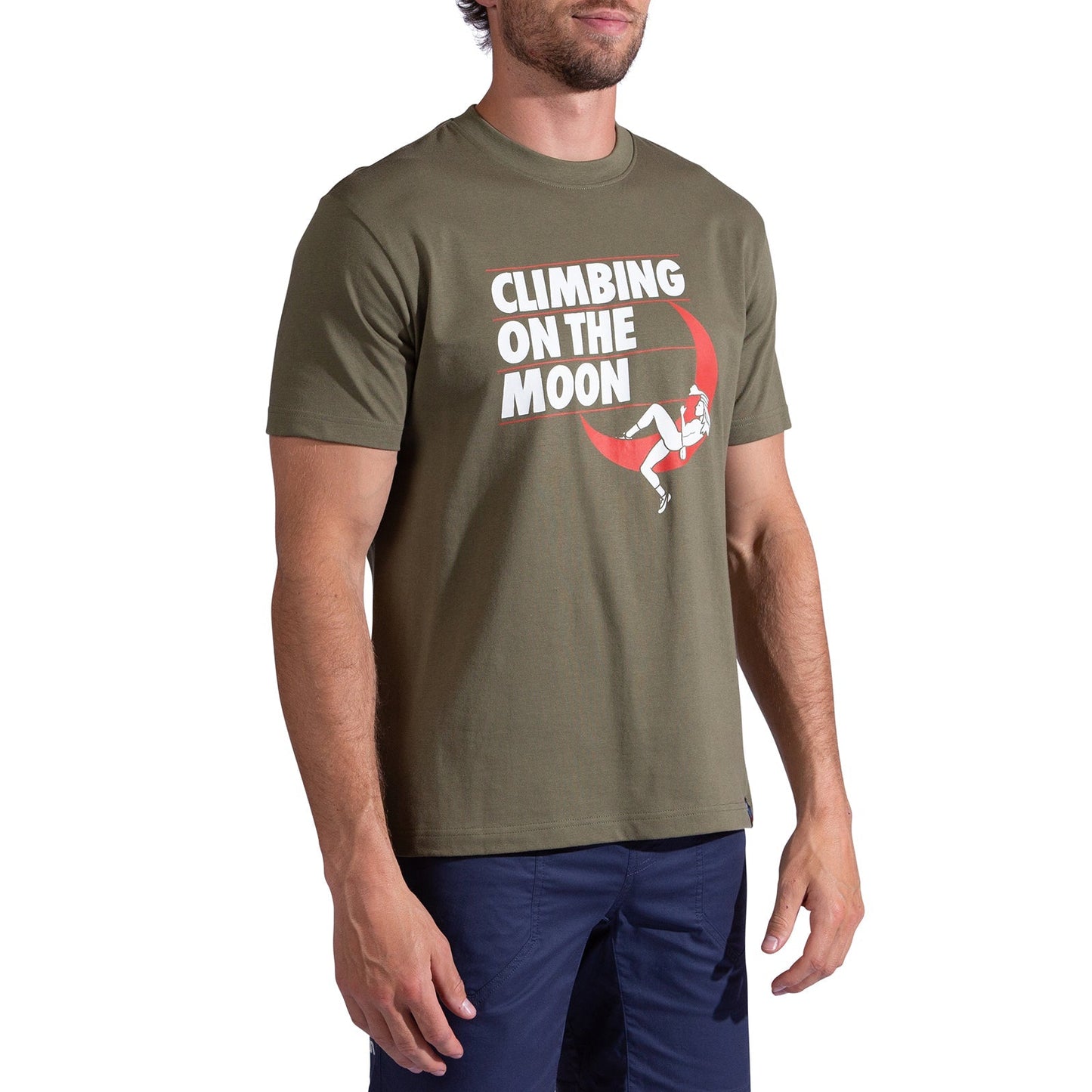 A man wears the La Sportiva Moon Rock T-Shirt Men's in olive green, made from organic cotton with "CLIMBING ON THE MOON" and a climber on a red crescent. He pairs it with navy shorts; his head is partially out of frame.