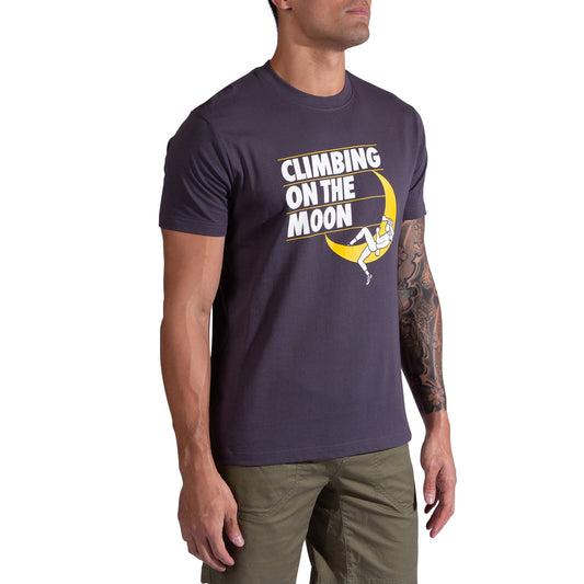 A man in the La Sportiva Moon Rock T-Shirt Men's featuring “CLIMBING ON THE MOON” and a climber on a crescent moon pairs it with olive green pants for a climb-inspired look.