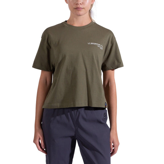 A person stands facing forward in a La Sportiva Since 1928 Crop T-Shirt Women's in olive green, featuring small white chest text, paired with dark gray pants against a white background. Organic cotton makes it perfect for climbing or casual wear.