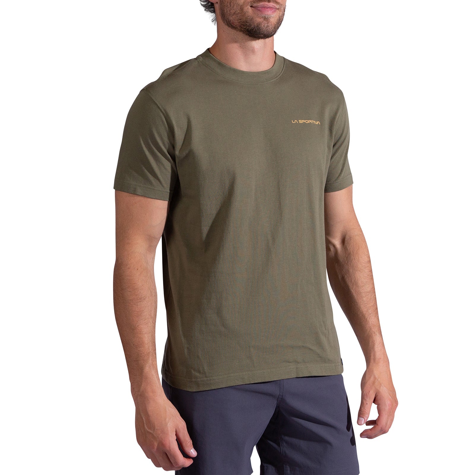 A man wears the La Sportiva Psychotomic T-Shirt Men's, an olive green organic cotton short-sleeve tee with a small yellow logo on the left chest, paired with dark shorts, standing against a white background.