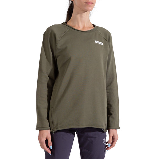 A woman wears the La Sportiva Tufa Sweater Women's in olive green, featuring a small white logo on the chest, and dark pants. She stands against a white background with her face partially out of frame.