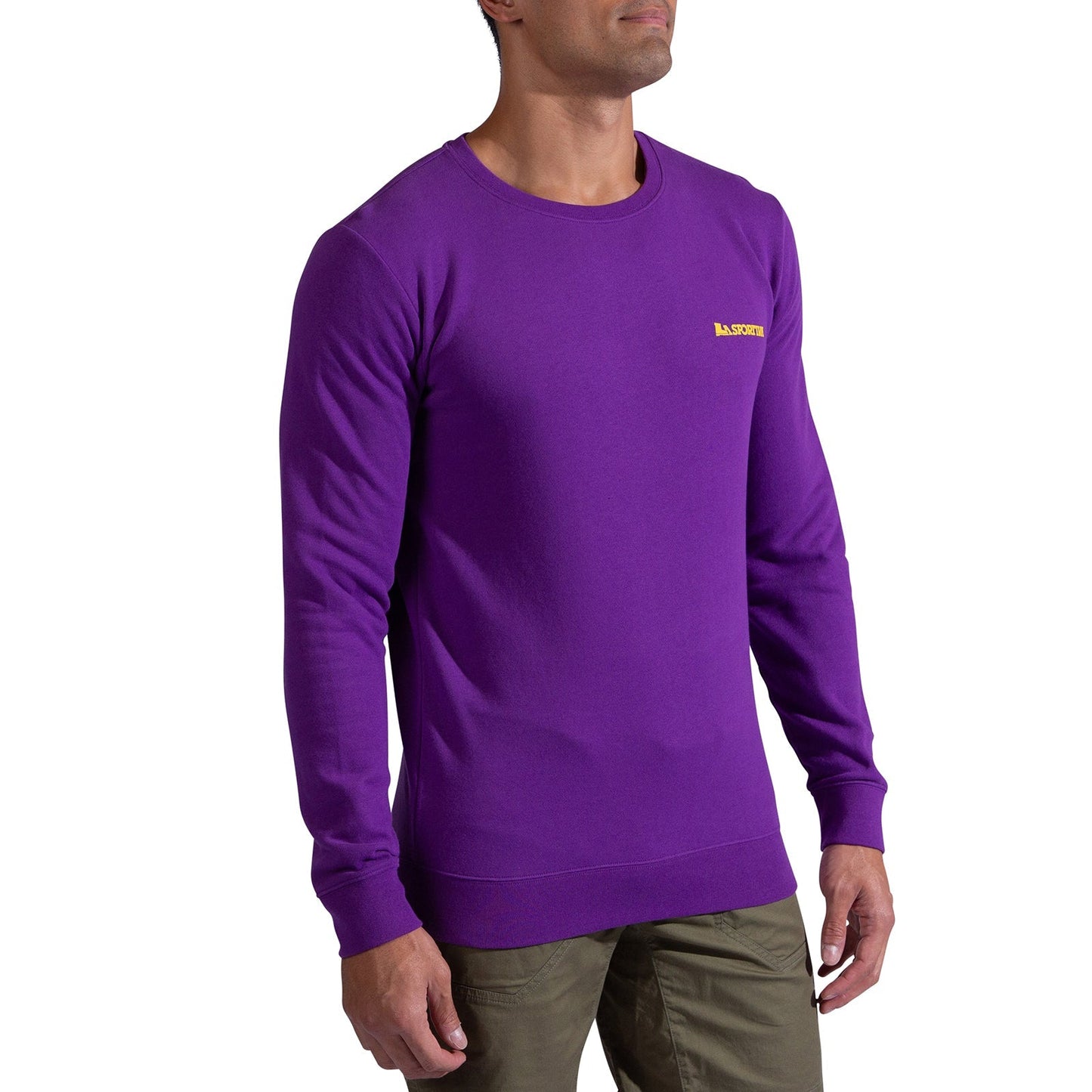 A man wears the La Sportiva Climbing on the Moon Sweatshirt Men's, a plain purple long-sleeve with a small yellow logo on the left chest, paired with olive green pants, standing against a white background.