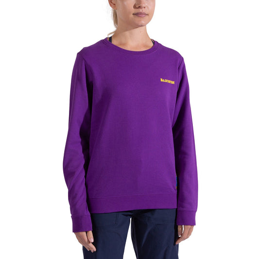 A woman in a bright purple La Sportiva Climbing on the Moon Sweatshirt Women's with a small yellow logo on the chest and dark pants stands against a plain white background. Her face is partially visible.
