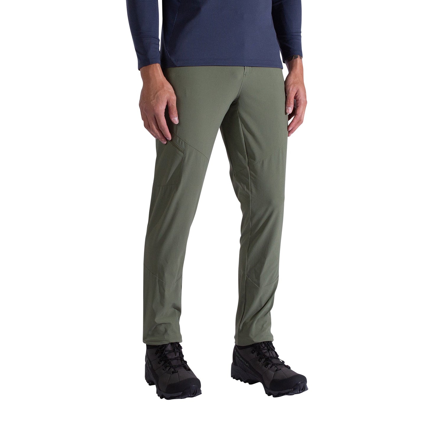 A person wearing La Sportiva West Crest Pants Men's in olive green, a navy long-sleeve shirt, and black hiking boots stands against a plain white background.