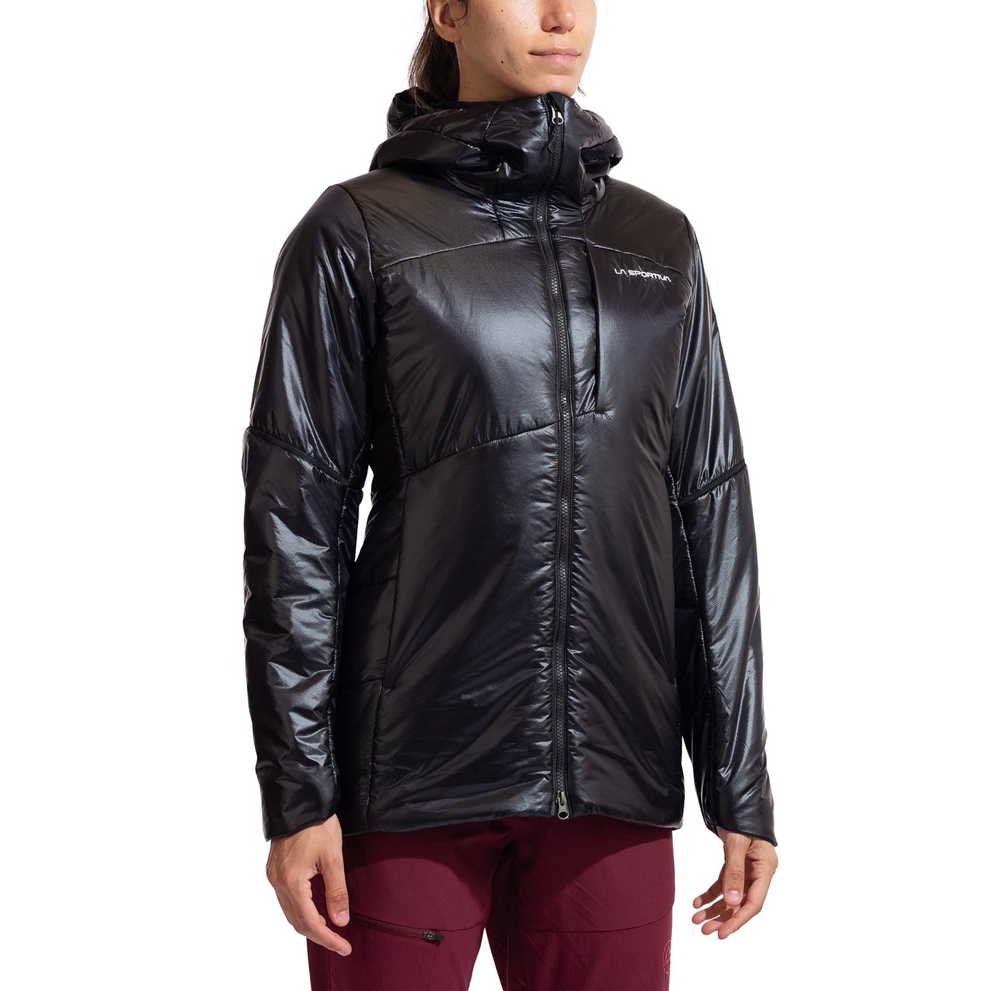 A woman in a shiny black La Sportiva Supercouloir Primaloft Parka with front zipper and maroon pants stands against a white background. The technical mountaineering jacket shows a subtle chest logo.