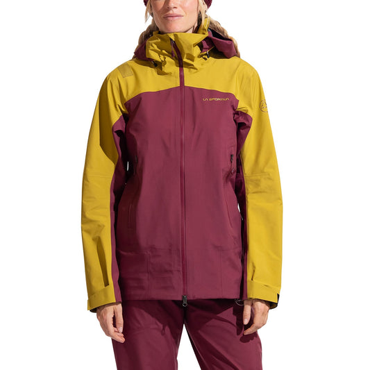 A woman faces forward against a white background, wearing the La Sportiva Alpine Guide GTX Performance Jacket with a maroon body and yellow shoulders, sleeves, and hood—designed for alpine activities.