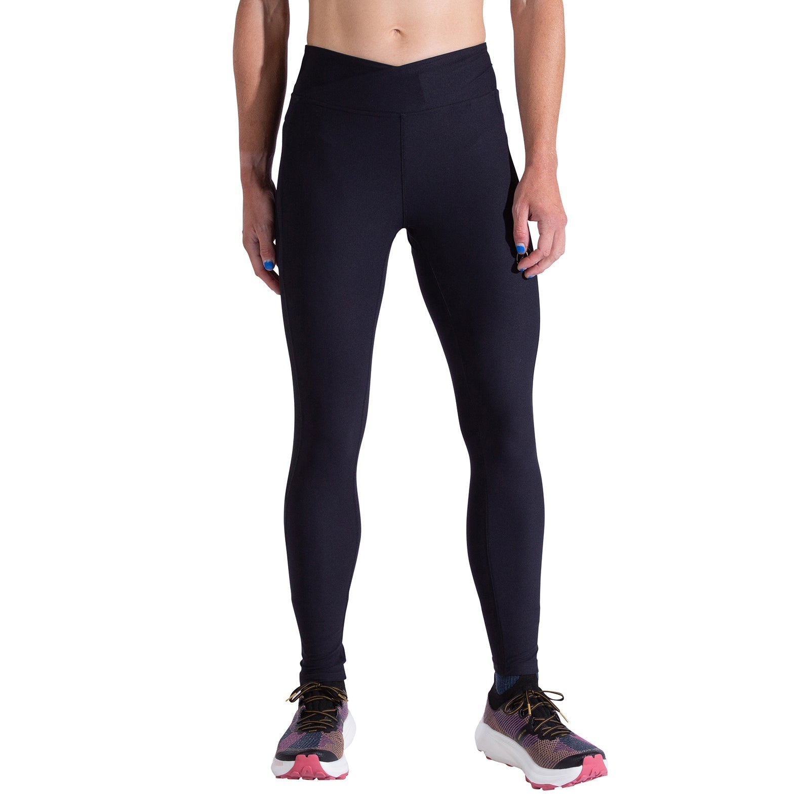 A person in La Sportiva Triumph Tight Pants Women's, made from recycled fabric, and multicolored running shoes stands against a white background with their upper body out of frame.