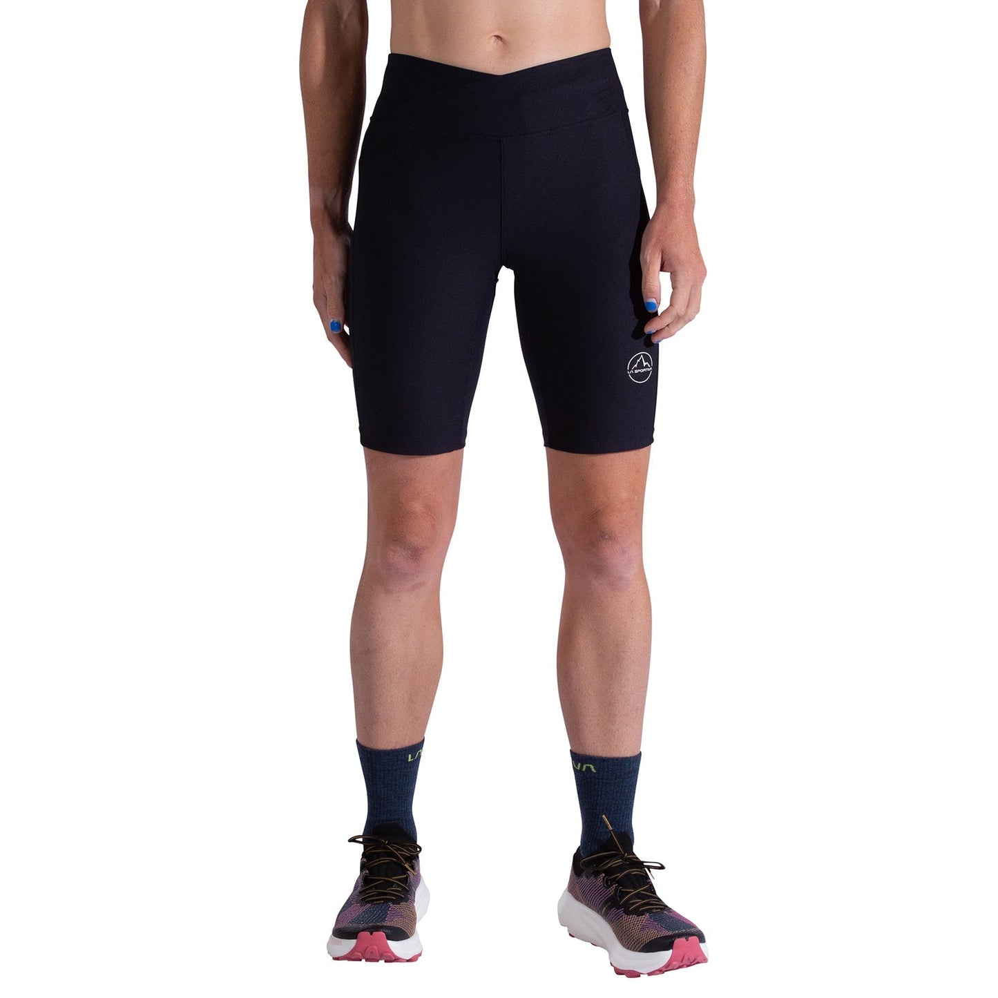 A person wearing La Sportiva Triumph Tight Shorts Women's, crafted from recycled fabric, with dark socks and colorful running shoes, stands facing forward against a white background, arms relaxed at their sides.