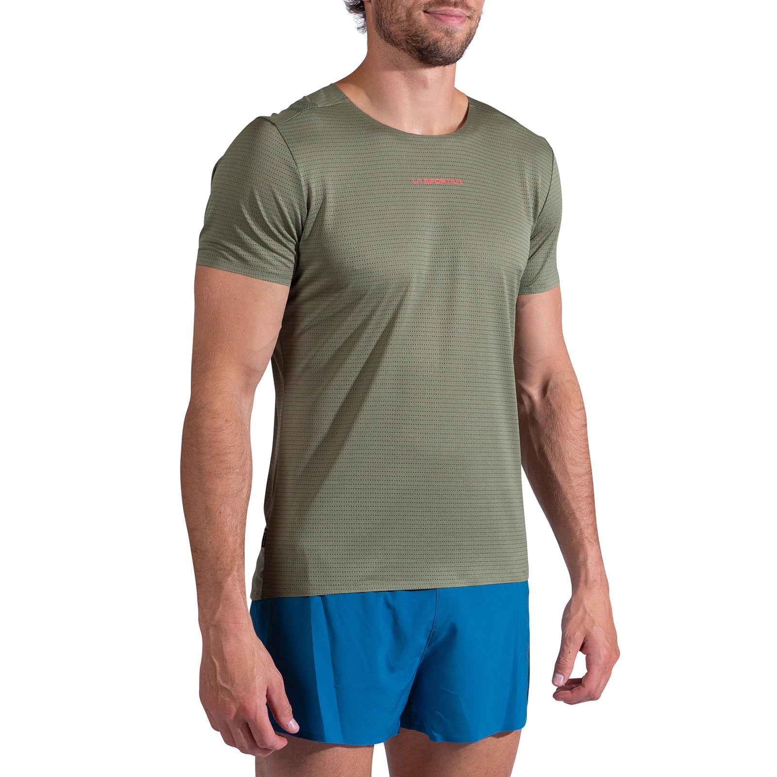 A man wearing a La Sportiva Pure T-Shirt Men's in light green and bright blue shorts stands facing slightly to the side against a white background. The short-sleeve running top is made from recycled polyester.