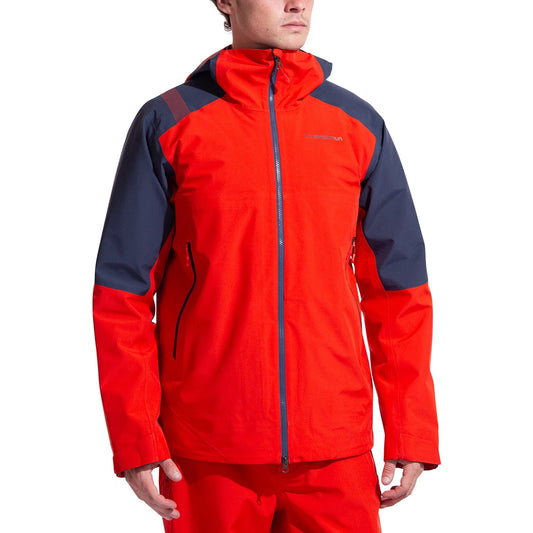 A person models the La Sportiva Crest Evo Shell Jacket Men's—a bright red shell with dark gray shoulders and sleeves, helmet-compatible hood, and front zipper—standing relaxed, facing slightly left against a plain white background.