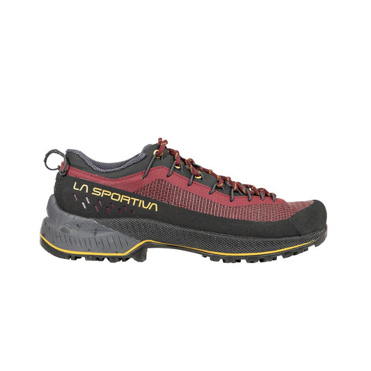 The La Sportiva TX4 EVO ST Women's is a maroon and black approach shoe with yellow accents, red laces, side branding, a rugged textured sole for outdoor use, and is fully resoleable for lasting performance.