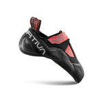 The La Sportiva Theory Women's climbing shoe, black and red with a Velcro strap and aggressive downturned shape, features No-Edge technology and has the brand name on the side. Photographed on a white background.