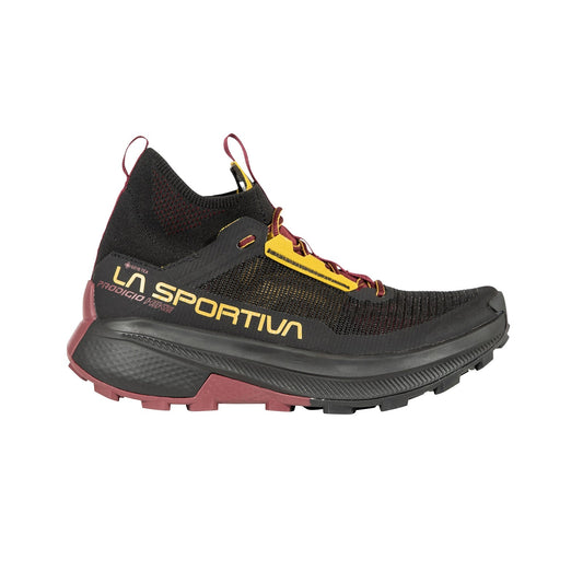 The La Sportiva Prodigio Hike GTX is a black and maroon trail running shoe with yellow accents, large yellow La Sportiva branding on the side, a high-grip sole, and is ideal for mountain hikes—shown in profile on a white background.