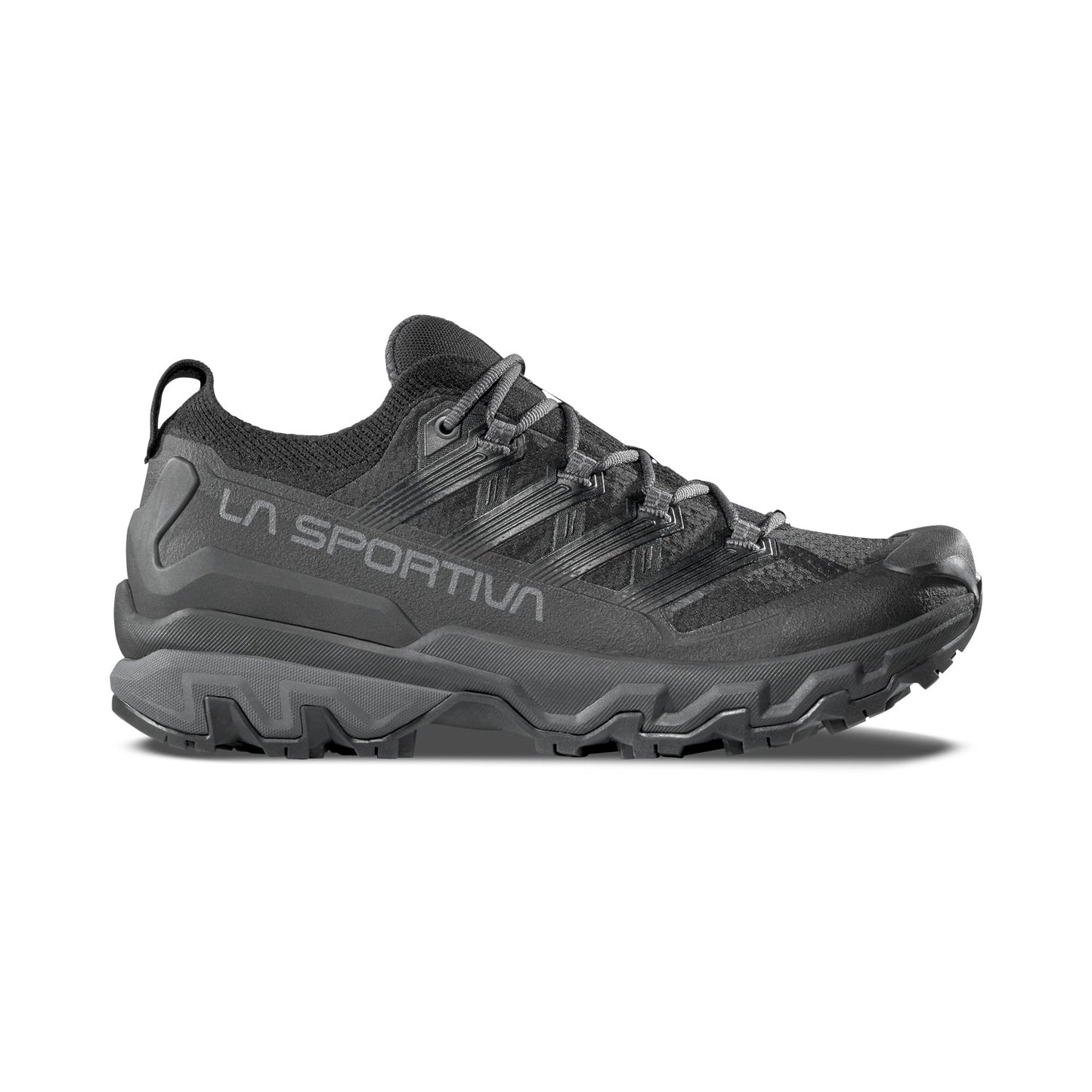 The La Sportiva Ultra Raptor 3, shown in black with side branding, features a rugged textured sole, breathable mesh upper, and reinforced toe—captured in side profile on a white background.