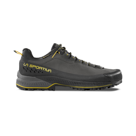 The La Sportiva TX5 EVO GTX is a black and dark gray athletic shoe with yellow accents, featuring a rugged sole for outdoor use—ideal lightweight hiking shoes offering durability and comfort.