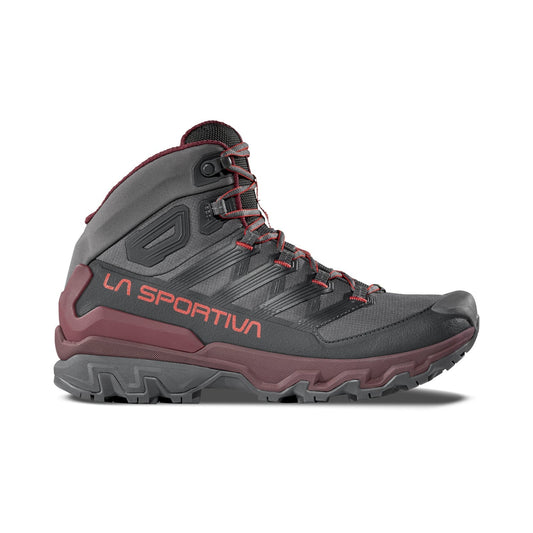 The La Sportiva Ultra Raptor 3 Mid GTX hiking boot features a dark grey and burgundy waterproof design, orange LA SPORTIVA branding, rugged sole, ankle support, and red-accented laces, displayed on a white background.