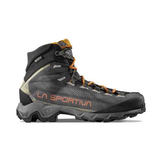 The La Sportiva Aequilibrium Hike GTX is a black and orange mid-cut boot with rugged tread, high ankle support, abrasion-resistant materials, orange laces, and bold La Sportiva branding on the side.