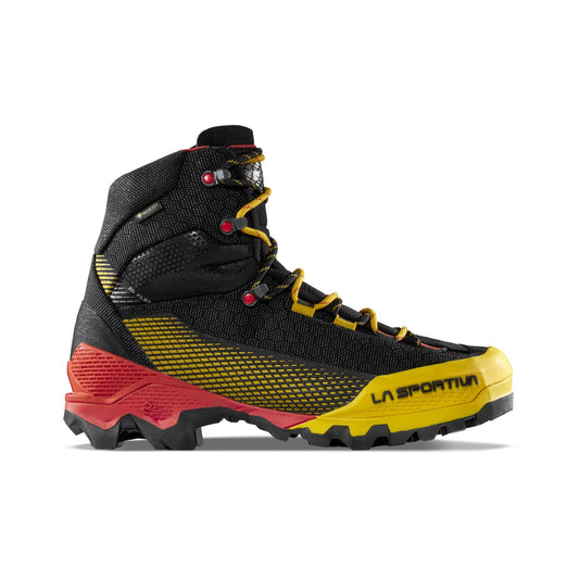 The La Sportiva Aequilibrium ST GTX is a high-top mountain boot with black mesh, yellow accents, red heel, rugged sole, and yellow La Sportiva branding—crafted for outdoor and alpine adventures.