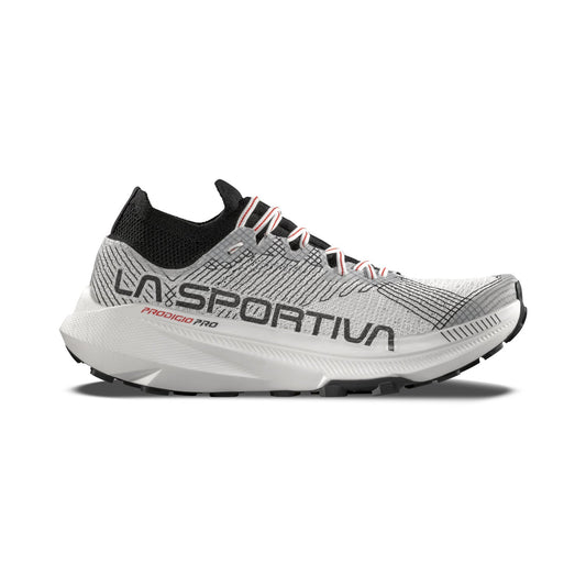 The La Sportiva Prodigio Pro is a gray and white trail running shoe with black laces, a black heel, LA SPORTIVA side branding, and a thick cushioned sole. Designed for ultra runners, it offers modern style and breathable comfort.