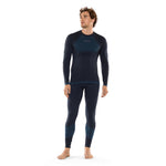 A man stands barefoot against a plain white background, wearing the La Sportiva Synth Light Long Sleeve Men's top and matching leggings in navy blue with darker panels—an ideal outfit for winter aerobic activities.