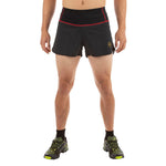A person wears La Sportiva Tempo Shorts Men's—black with red trim and logo, featuring a lightweight recycled-material waistband—paired with black socks and green running shoes. Only the lower body is shown against a white background.