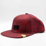 The La Sportiva Dimension Hat features a red patterned flat brim, a black La Sportiva logo patch, and yellow and white accents—perfect for completing your climbing outfit. Shown against a plain white background.